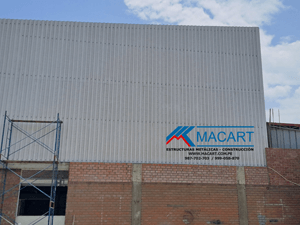 Vista del cerramiento lateral del almacén con paneles aluzinc.